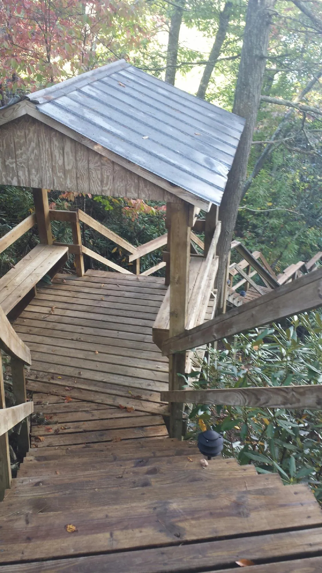 Metal roofed shelter over wooden steps on a wooded walkway — Skylight Repair & Installation work by our crew in Gibsonville