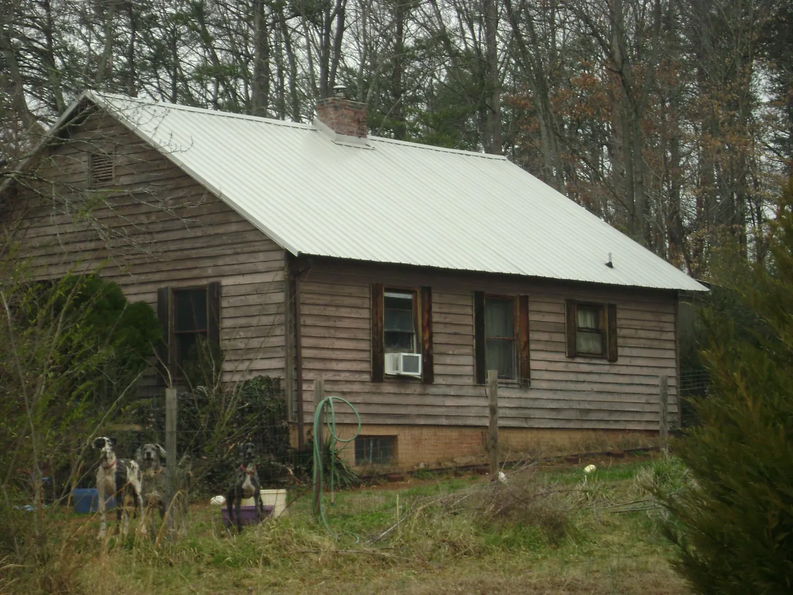 White metal roof on an old wood sided farmhouse, from a Metal Roof Installation job in Gibsonville